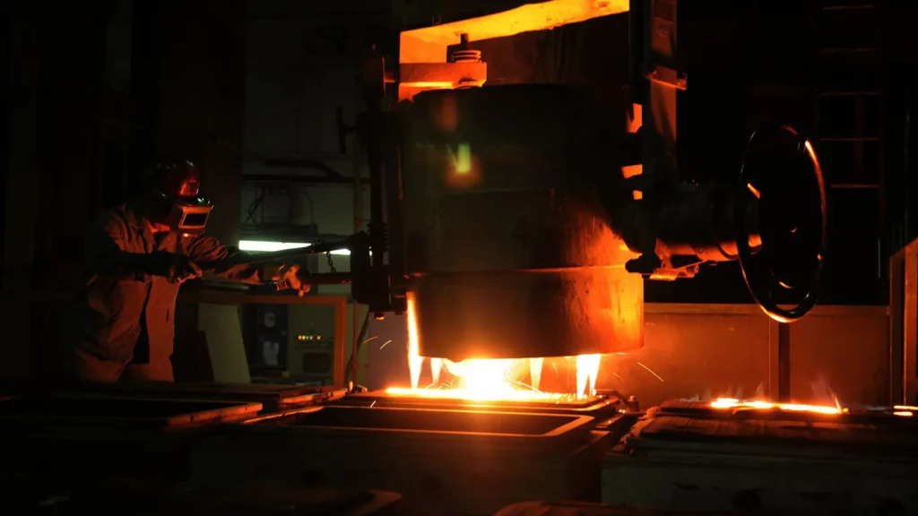 Arbeiter gießt heißes Metall ab